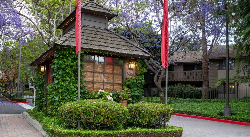 Settle into comfort at Aspen Village a guard shack with shrubbery around it